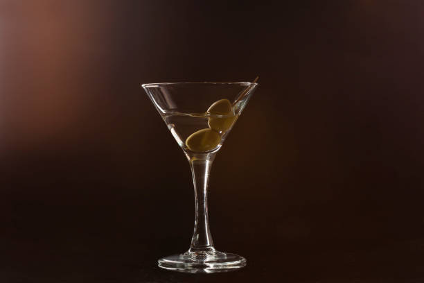 istock Martini glass with olives on black background 1414349051