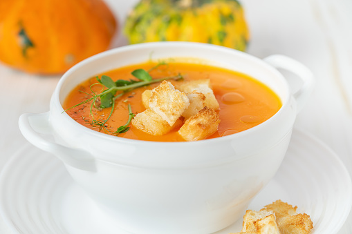 Pumpkin soup with croutons on white background