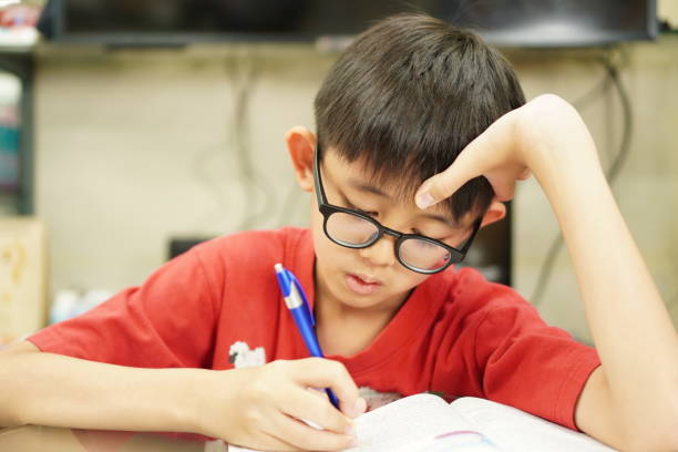 istock Image: kid is doing their homework intently, portrait, close-up 1414354255