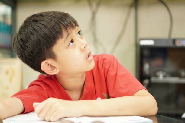 istock Image: Kid is imagining to find someone to help solve math problems, portrait, close-up 1414354279