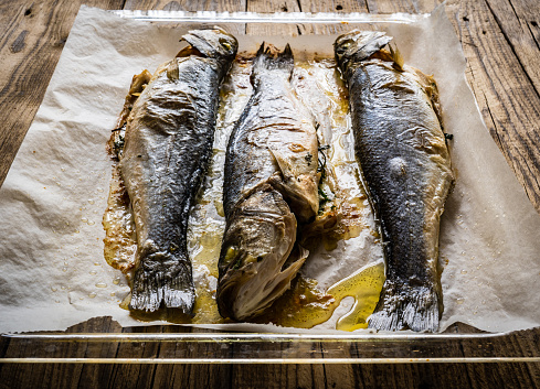 Fish dish - roasted trout on baking paper in cooking pan