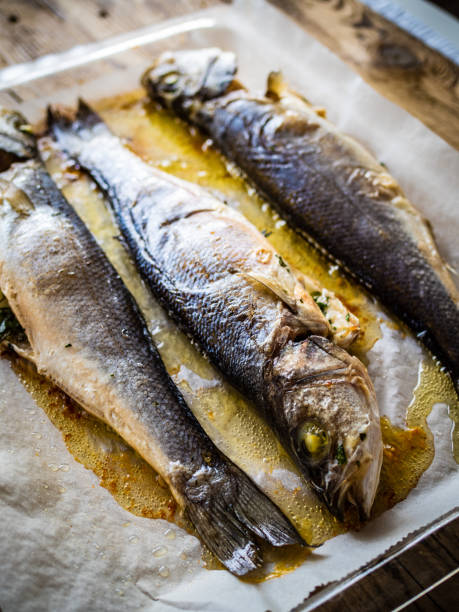 istock Fish dish - roasted trout on baking paper in cooking pan 1414356564