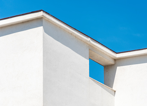 White detail of a building against the blue sky on blue