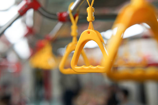 selective focus on yellow hanging handle grip on public transportation such as bus and train  can be s source of virus infection and health issues.