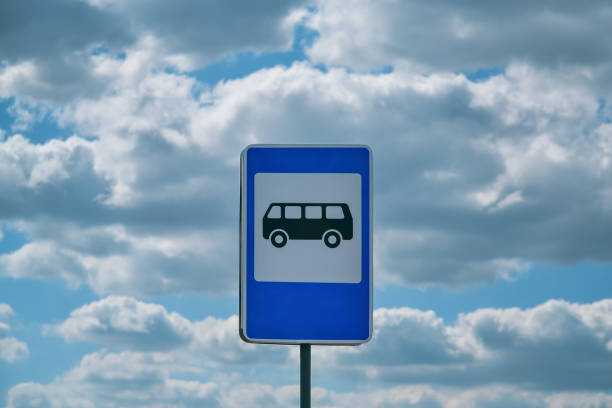 blau-weißes bushaltestellenschild, das einen bus vor weißen wolken und blauem himmel darstellt - heaven hell road sign sign stock-fotos und bilder