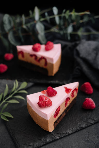 istock Pieces of cheesecake with raspberries on black board 1414371042