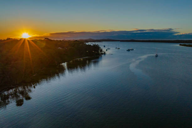 istock Sunrise over the river with boats and a sunburst 1414371603