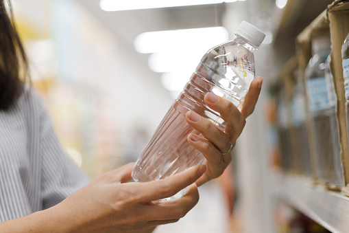 Cropped shot of a woman buying bottled water in supermarket