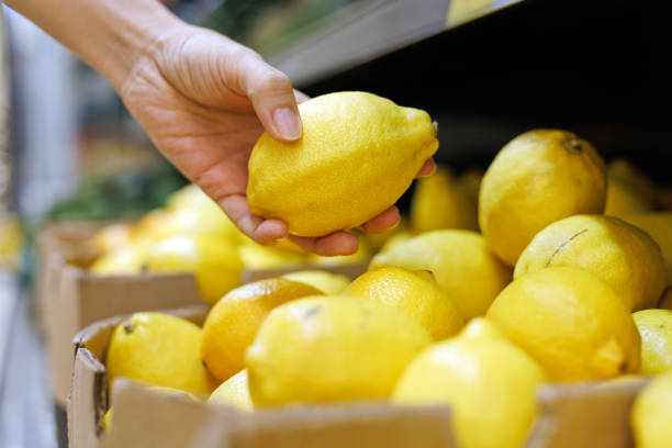 istock Customer choosing lemon at grocery store close up 1414372566