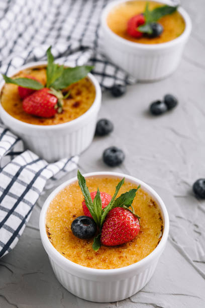 istock cup of creme brulee with dessert plug and mint leave with berries 1414374118