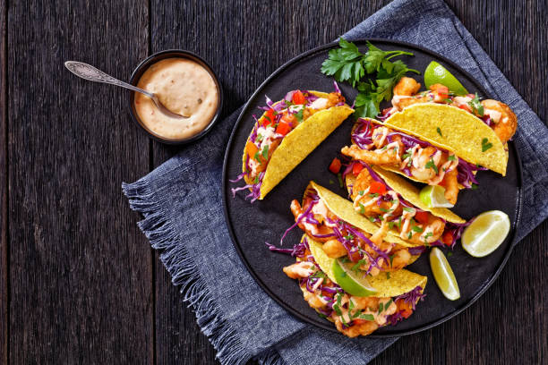 istock Bang Bang Shrimp Tacos on black plate with sauce 1414378052