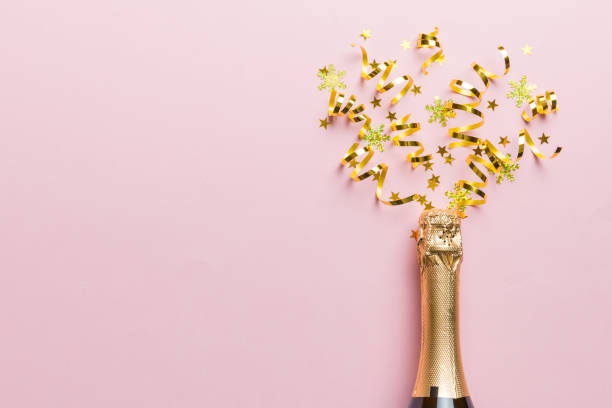 istock Creative flat lay composition with bottle of champagne and space for text on color background. Champagne bottle with colorful party streamers. holiday or christmas concept 1414378539