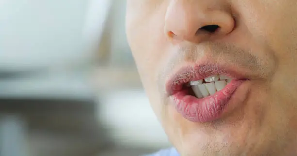 Close-up of mature man with pink lips talking.