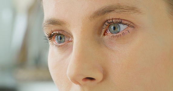 Close-up of thoughtful woman with hazel eyes looking away.