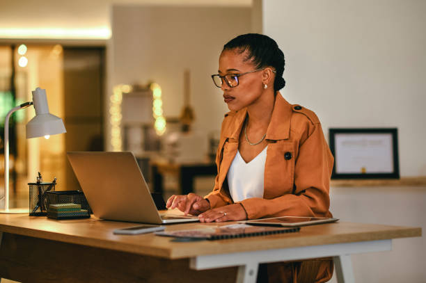 istock Creative, thinking and serious female manager looking at computer, reading or writing email in home office. Woman in glasses sitting at desk concentrating while working on the laptop. 1414378871