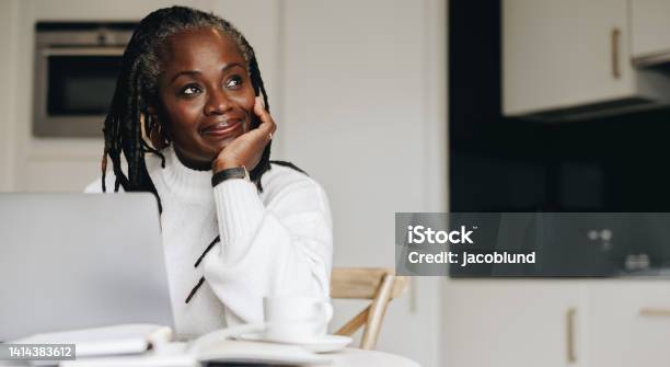 Mature Businesswoman Looking Away Thoughtfully In Her Home Office Stock Photo - Download Image Now
