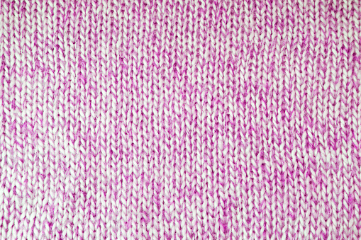 Close up background of knitted wool fabric with dots pattern. Bright purple color crumpled knitting wool knitwear texture. Openwork abstract knitted jersey fabric abstract backdrop