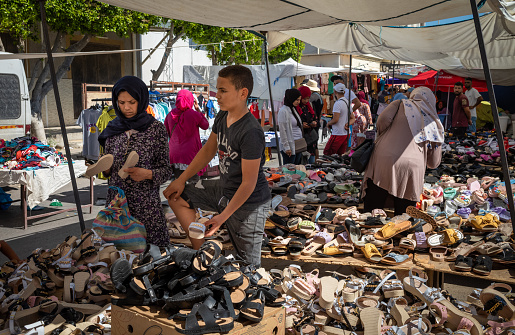 A young man sells women's shoes at the Sunday Souk, a weekly market in Sousse, Tunisia.