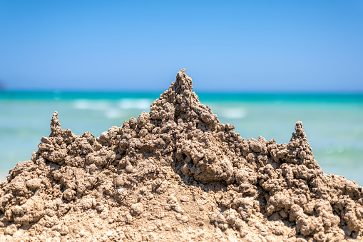 sandcastle - in the background the turquoise blue water of the mediterranean sea