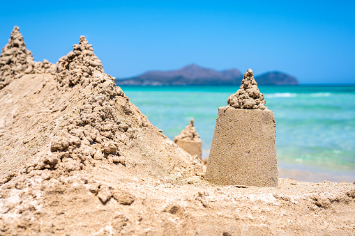 sandcastle - in the background the turquoise blue water of the mediterranean sea