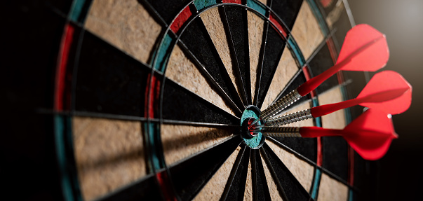 red darts in the dartboard center. business target or goal success and winner strategy concept. banner with copy space