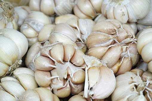 Garlic, onion and Spanish onion on a wooden plate, seasoning vegetables on a wooden kitchen table top, a top view with a copy space area