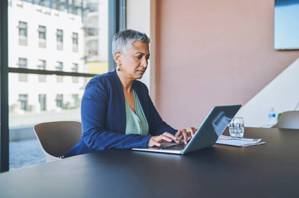 istock Manager, boss or senior executive working on a laptop while sitting at a desk in her professional office at work. Corporate female leader typing an email, report or managing her company online 1414393950