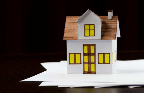 istock Toy house with a documents blank on the table 1414396168