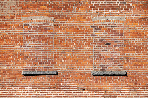 Two walled up windows on a brown stone wall in Beacon, which is a suburb to New York