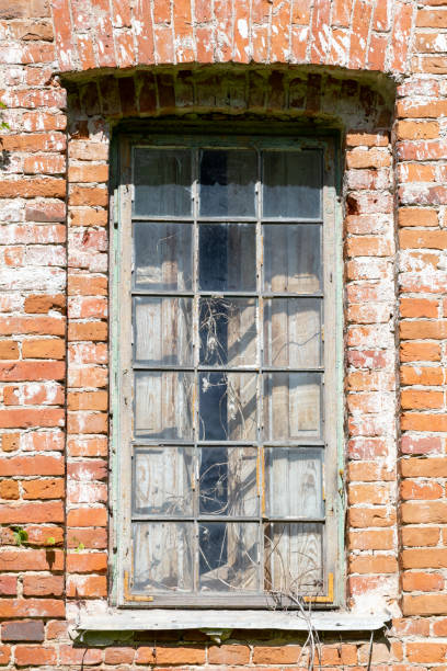 istock Broken window, of an old dilapidated deserted brick building 1414398492