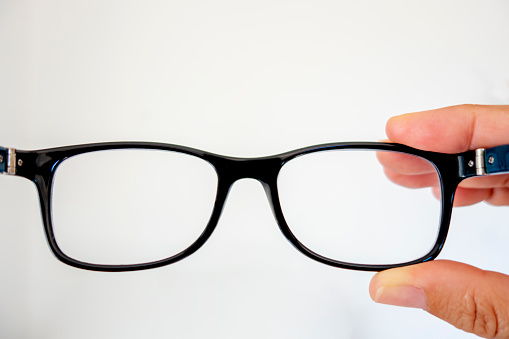 Glasses in man's hands close-up, white background