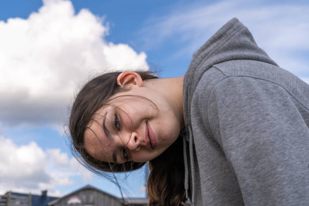 Cute smiling teenage girl with grey hoodie jacket outdoor. stock photo