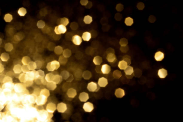 istock Golden blurred bokeh lights on black background 1414401116