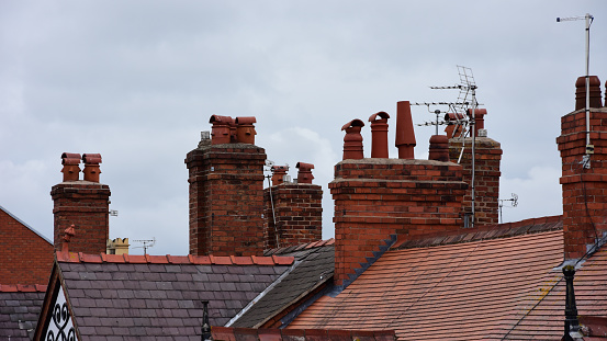 Clay chimney pots on the top of red brick chimney stack of a residential house