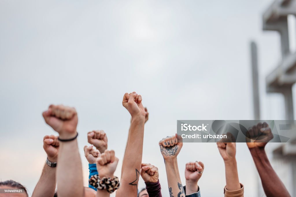 Protestors Raising Fists Close-up of protestors raising hands above their heads. Protest Stock Photo