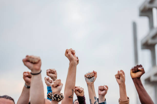 протестующие поднимают кулаки - protestor protest strike labor union стоковые фото и изображения