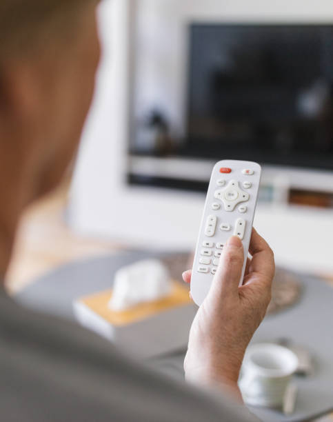 istock Senior woman with remote control watching tv 1414402862