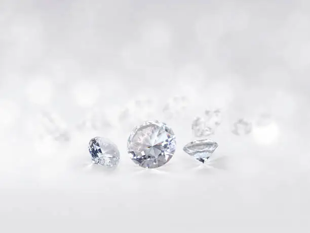 still with expensive cut diamonds in front of a white background, reflections on the ground. Lot of copyspace