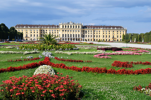 Vienna, Austria - August 01, 2022: Unidentified tourists and Schoenbrunn Palace from the 18th century - former residence of the Habsburg rulers and today a UNESCO World Heritage Site, world-famous tourist attraction situated in a large park landscape with the oldest zoo in the world