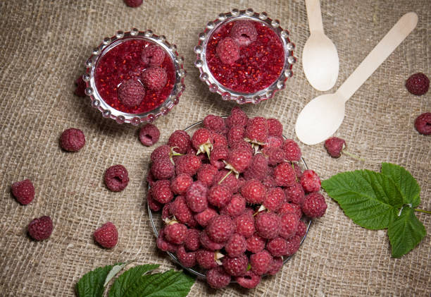 Fresh raspberries and jam in glass bowls. Delicious berry dessert