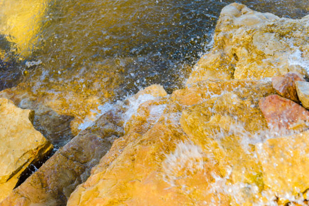 Beautiful cool and refreshing running stream along the stones and rocks on a bright summer day.Closeup.