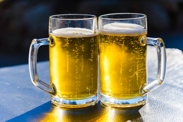istock Two glasses of light beer on a table sunset outdoors.Summertime.Closeup. 1414410136