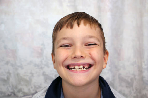 Boy smiles and shows his teeth. Close-up portrait.