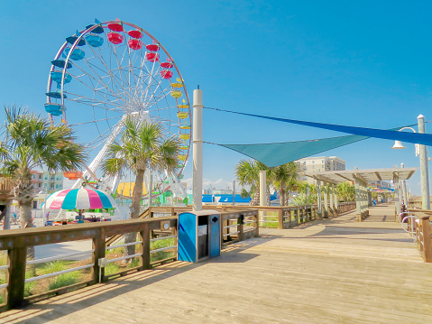A beautiful summer landscape of the new Ferris wheel by the boardwalk at Carolina Beach in North Carolina in a pastel color tone.