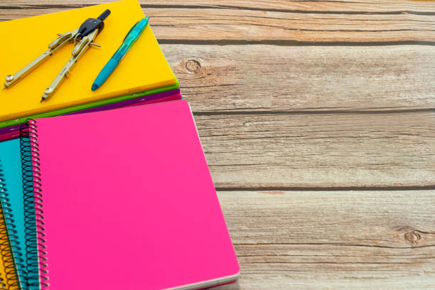istock Several colored notebooks with compass and pen on wooden table. Back to class 1414416827