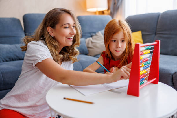 Mother and daughter practicing math using abacus stock photo