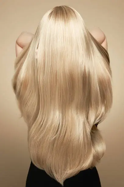 Photo of Back view of woman with long beautiful blond hair