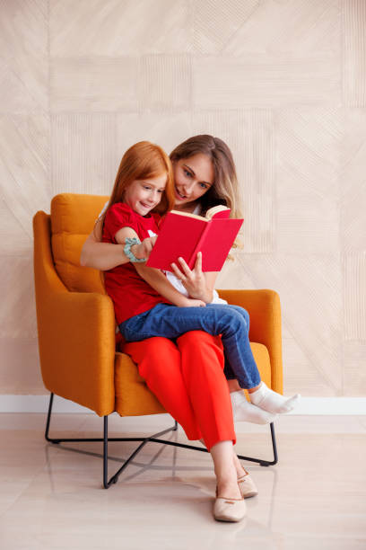 Mother reading a book to her little daughter stock photo