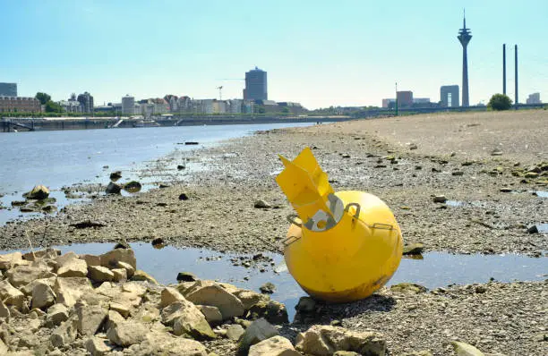 Low stream gauge of river rhine in the town of Düsseldorf,germany.Water shortage, drought, climate change,global warming, shipping disaster.