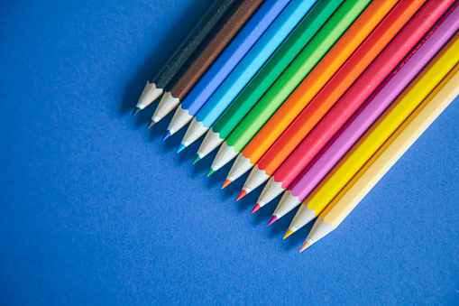 School supplies - color pencils on blue background